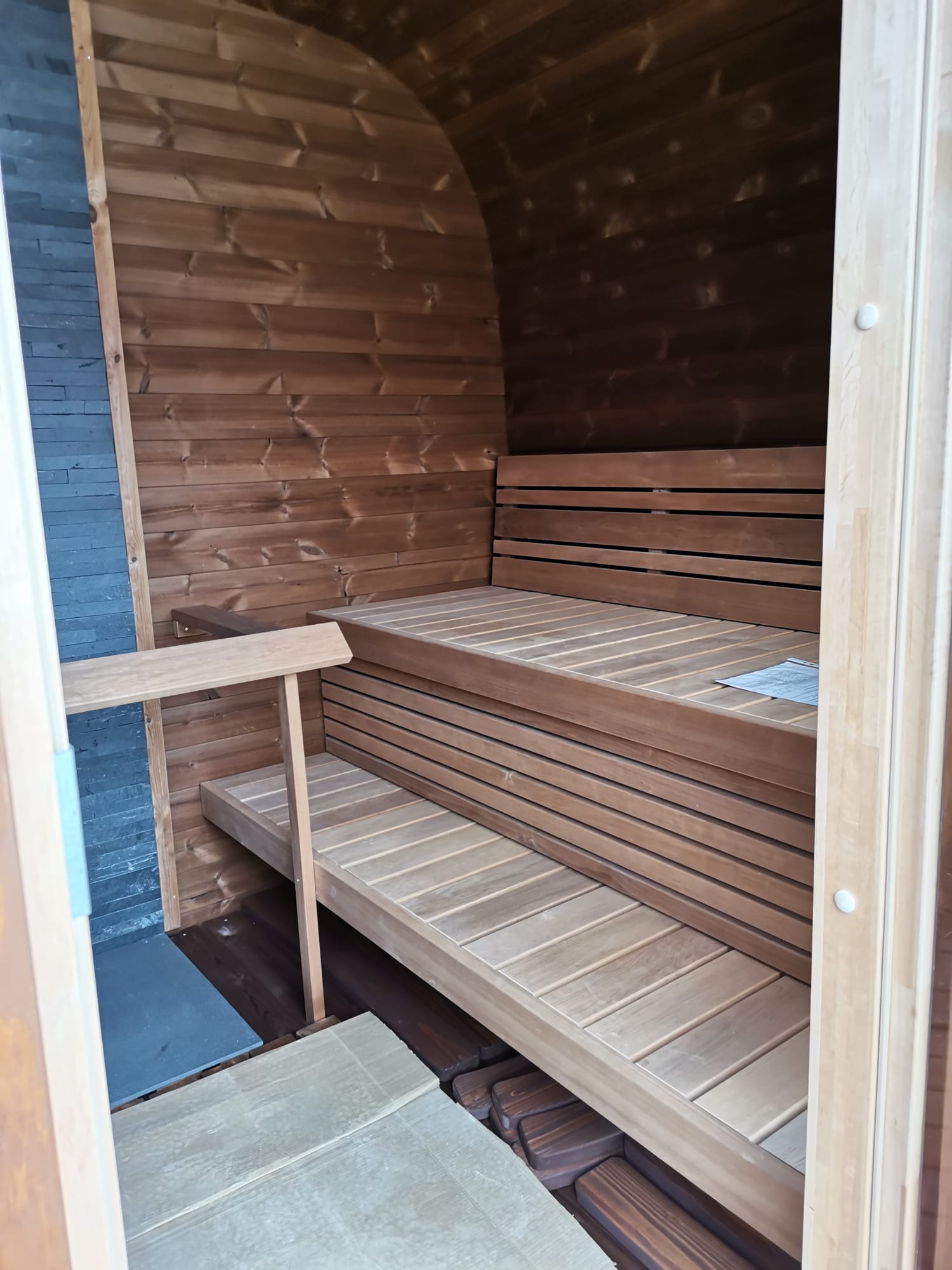 Sauna Exterior Cubus com bancos de madeira em ambiente interno.