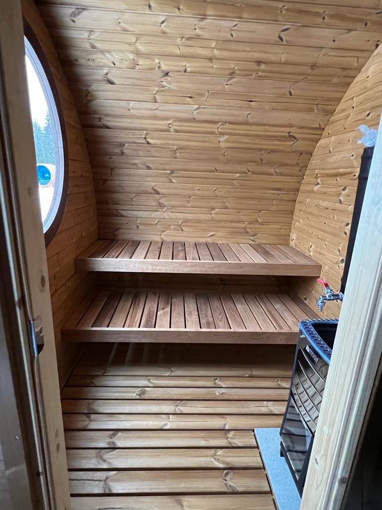 Sauna Exterior Hobbit 195 com janela circular e design curvilíneo.